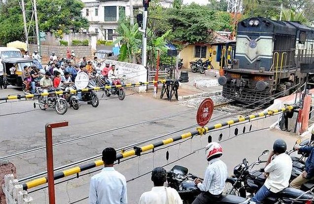 AI-generated generic Indian railway crossing with people waiting behind a closed gate